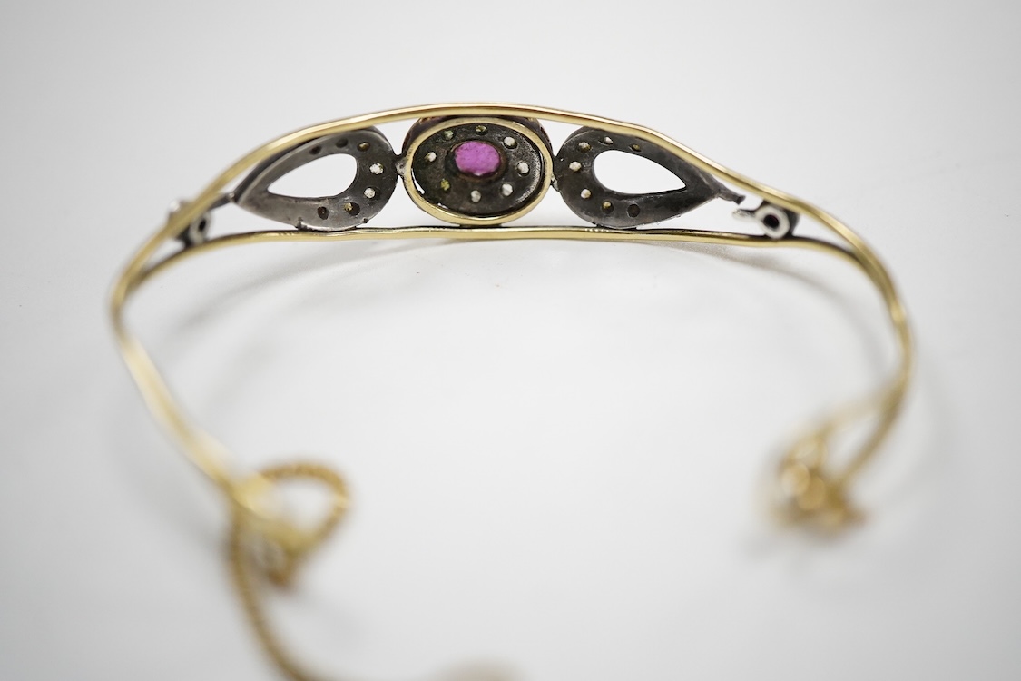 An Italian 18k and white metal, ruby and diamond cluster set bangle, with safety chain, gross weight 10.1 grams.